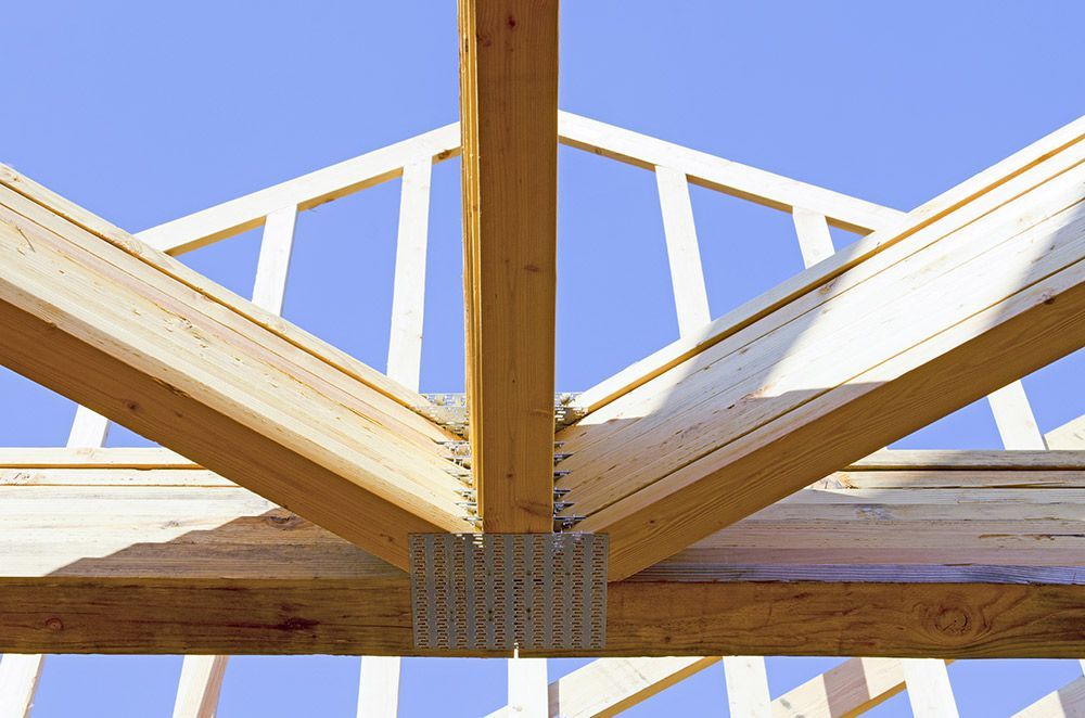 Carpenter Placing New Home Wood Trusses On A Residential Construction Site — Trussted Frames & Trusses in Cessnock, NSW
