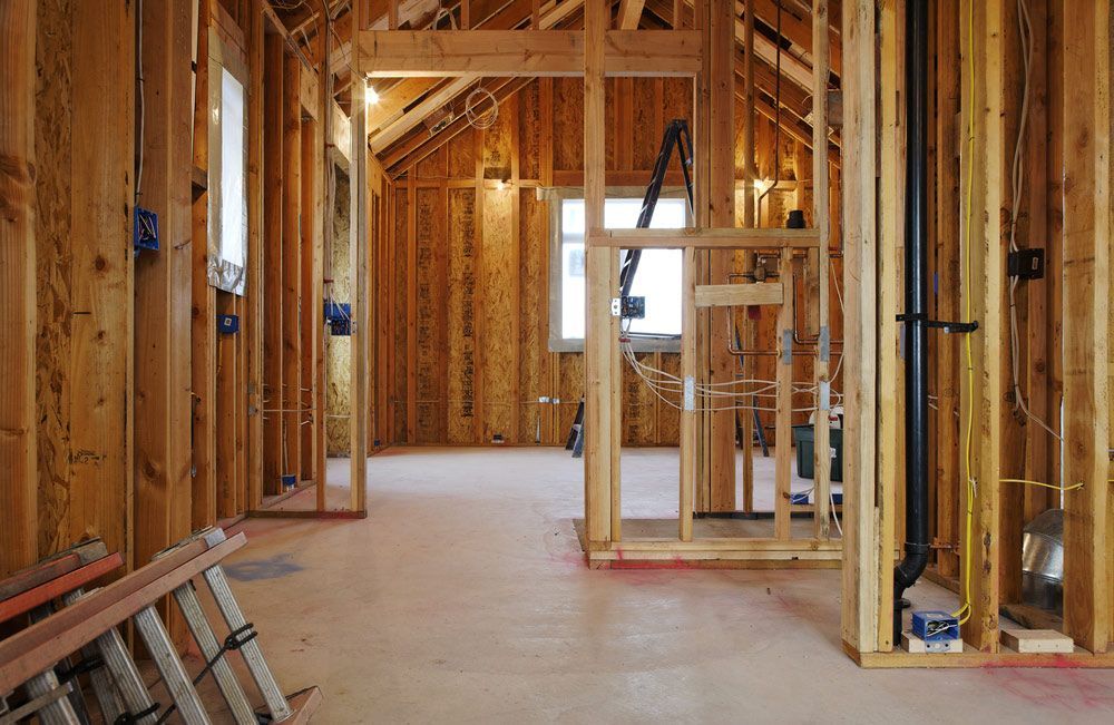 A House Is Being Built With Wooden Beams And A Ladder With Electrical Installation — Trussted Frames & Trusses in Singleton, NSW