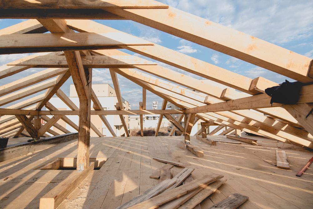 The Roof of A Building Is Being Built with Wooden Beams — Trussted Frames & Trusses in Bennetts Green, NSW