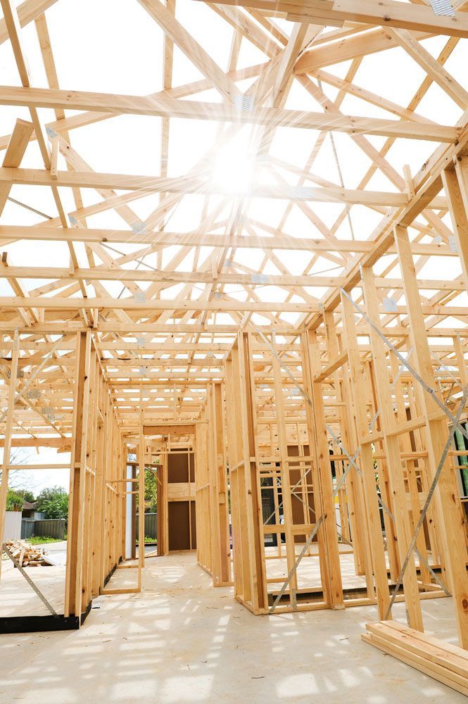 The Sun Is Shining Through The Roof Of A House Under Construction — Trussted Frames & Trusses in Armidale, NSW