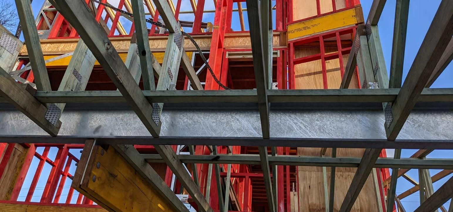 A Building Under Construction with A Crane in The Background — Trussted Frames & Trusses in Bennetts Green, NSW