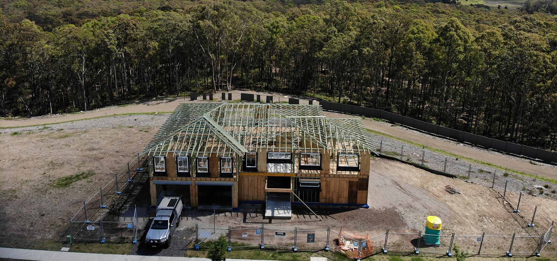 An Aerial View of A House Under Construction in The Middle of A Forest — Trussted Frames & Trusses in Newcastle, NSW