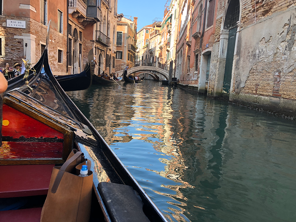 Felicia riding a gondola down a canal in venice.