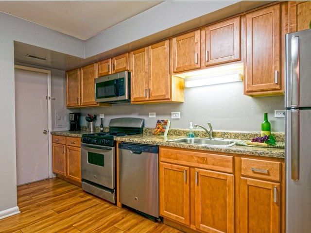 Modern kitchen with wooden cabinets, stainless steel appliances, and granite countertops