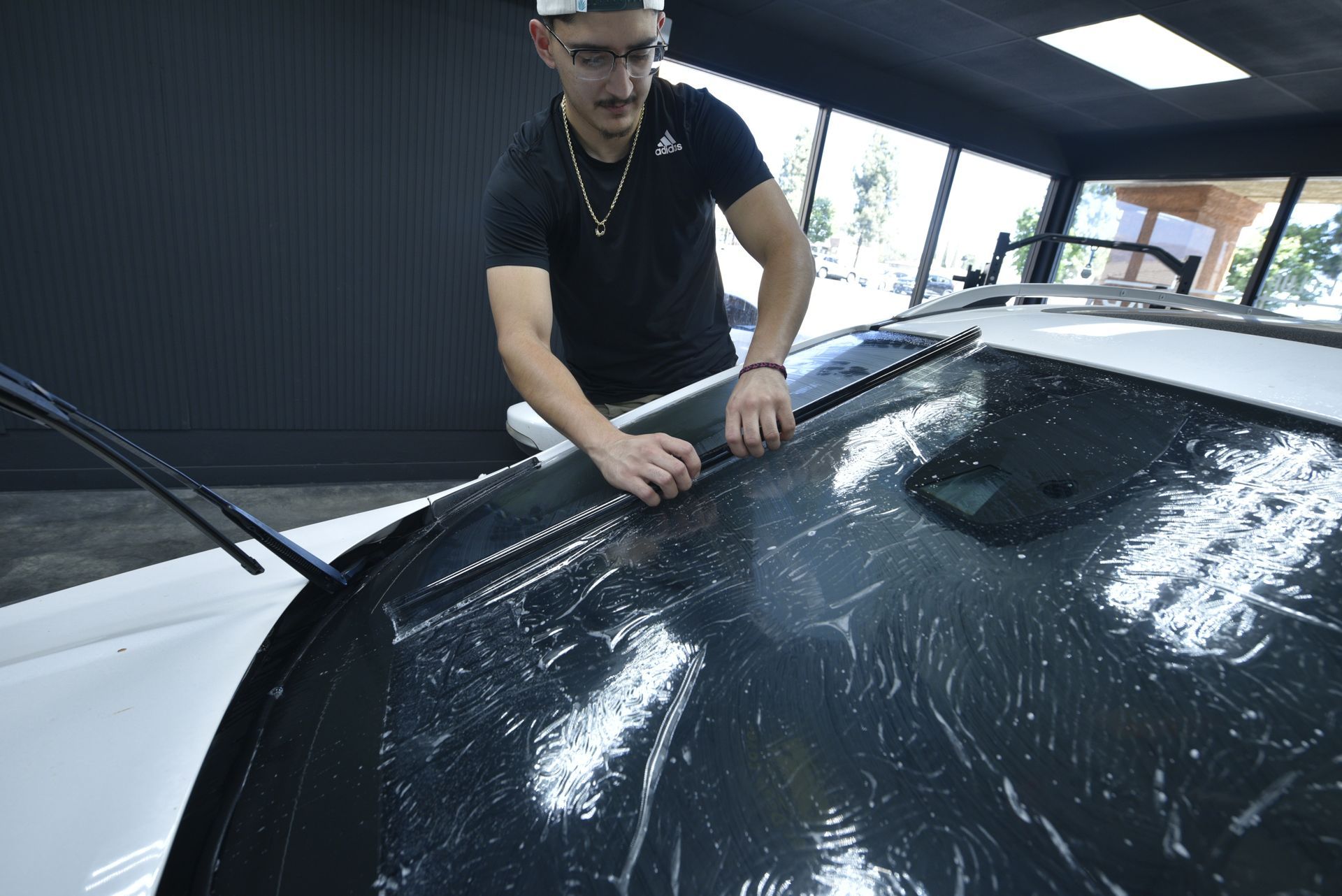 Person shaping window tint film for Automotive window tint at 99  Tint Club in Yucaipa