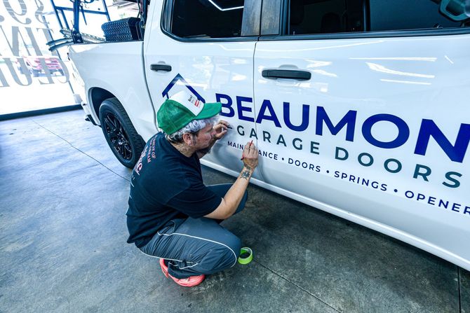 Person adding window tint film to a black car windshield in Yucaipa.
