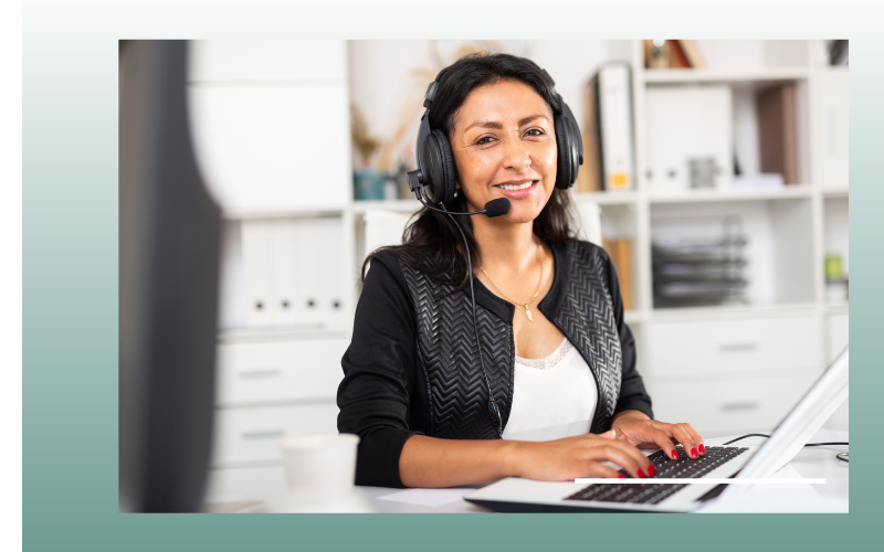 Woman wearing a headset working at a laptop in an office setting