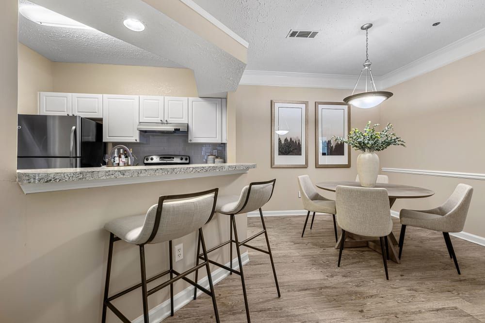 Apartment kitchen with spacious island and dining room with a table and chairs at Marquis at Sugarloaf, offers apartments near Sugarloaf Mills.