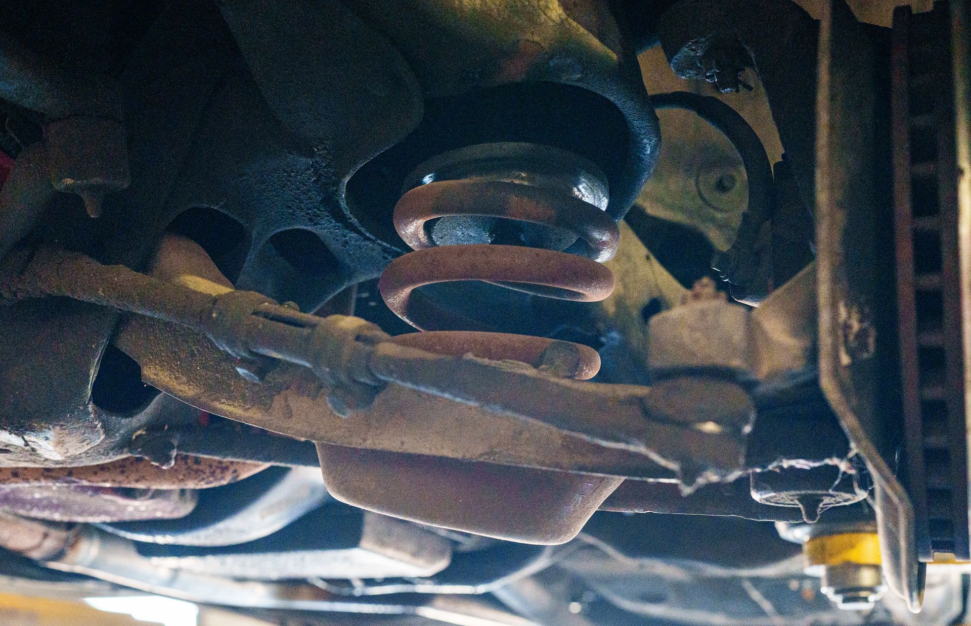 Undercarriage of a vehicle with suspension springs and dusty metal parts visible