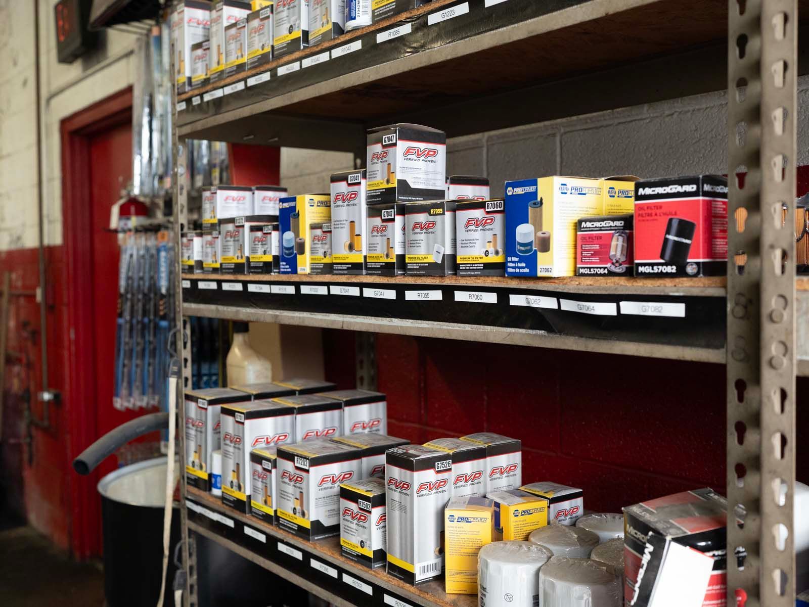 Shelved automotive products in a store aisle with red walls and metal racks