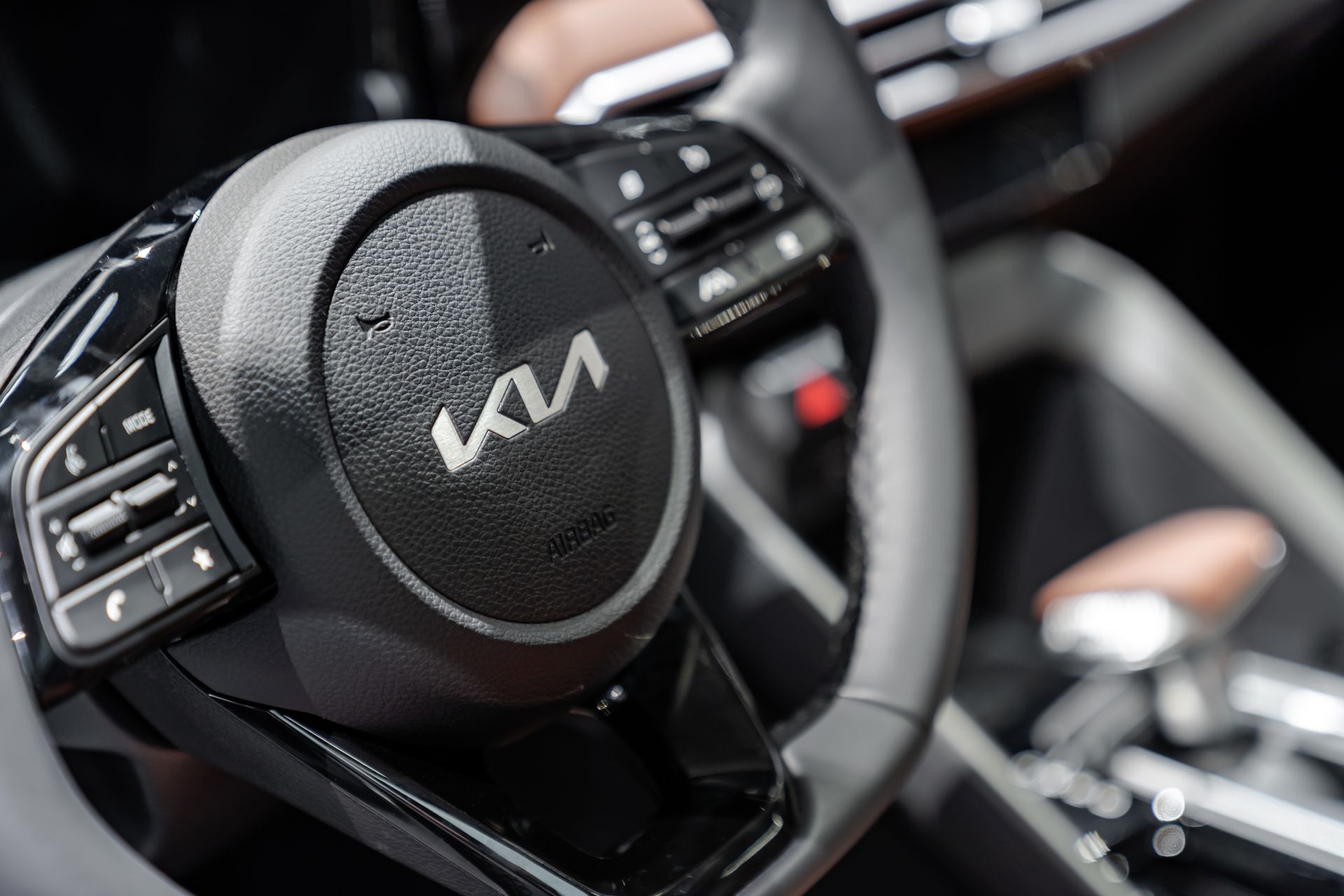 Close-up of a Kia steering wheel and dashboard inside a modern car interior