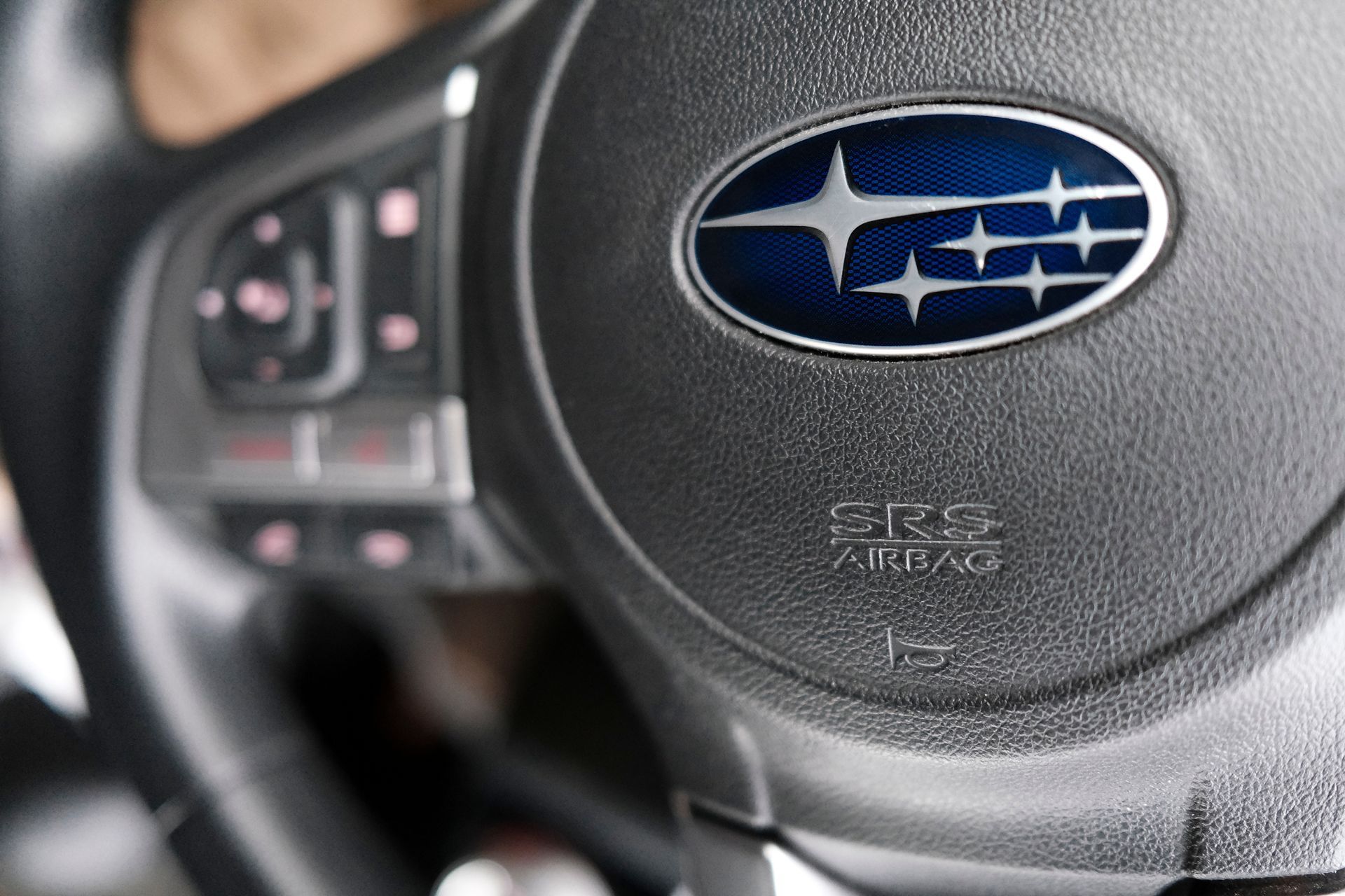 Close-up of a Subaru steering wheel with logo and control buttons