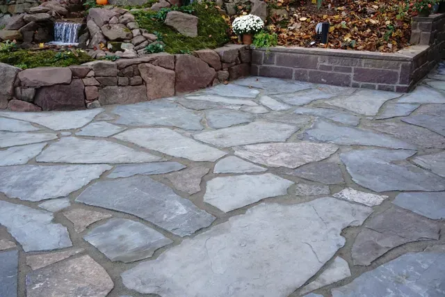 Flagstone patio with waterfall and stone planter.