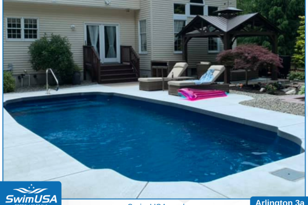 In-ground backyard pool with deck chairs and patio beside a house