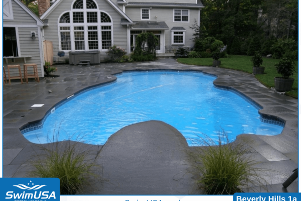 Backyard pool with bright blue water and gray stone deck beside a house
