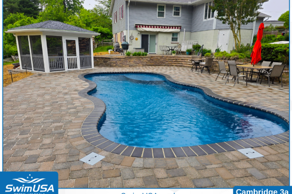 Backyard pool with curved blue water, stone patio, white gazebo, and outdoor dining area