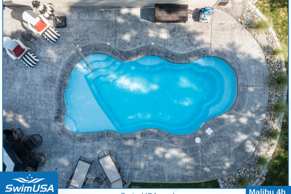 Aerial view of a bright blue backyard swimming pool with lounge chairs and trees nearby
