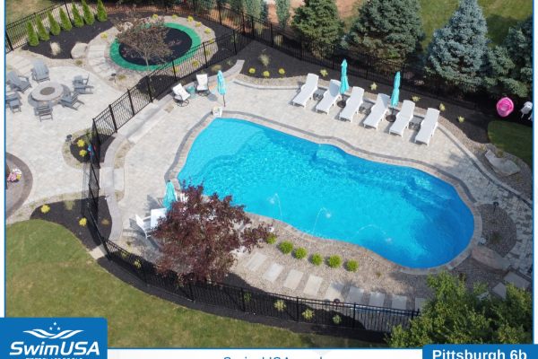 Outdoor swimming pool with curved blue water, lounge chairs, umbrellas, and surrounding patio seating.