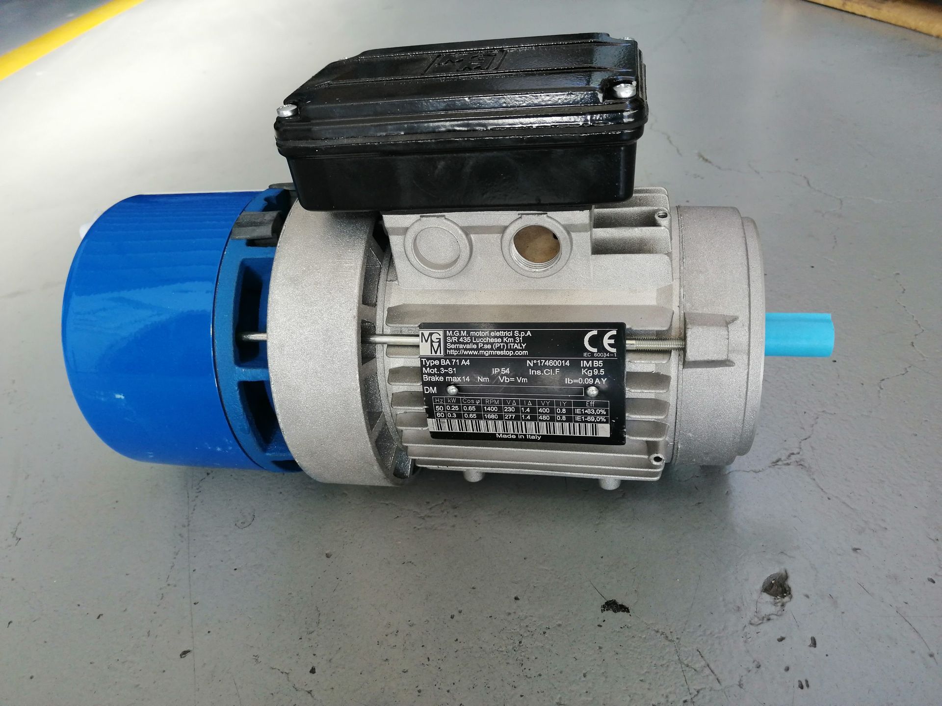 Motore elettrico con estremità blu, corpo argentato e scatola di giunzione nera.