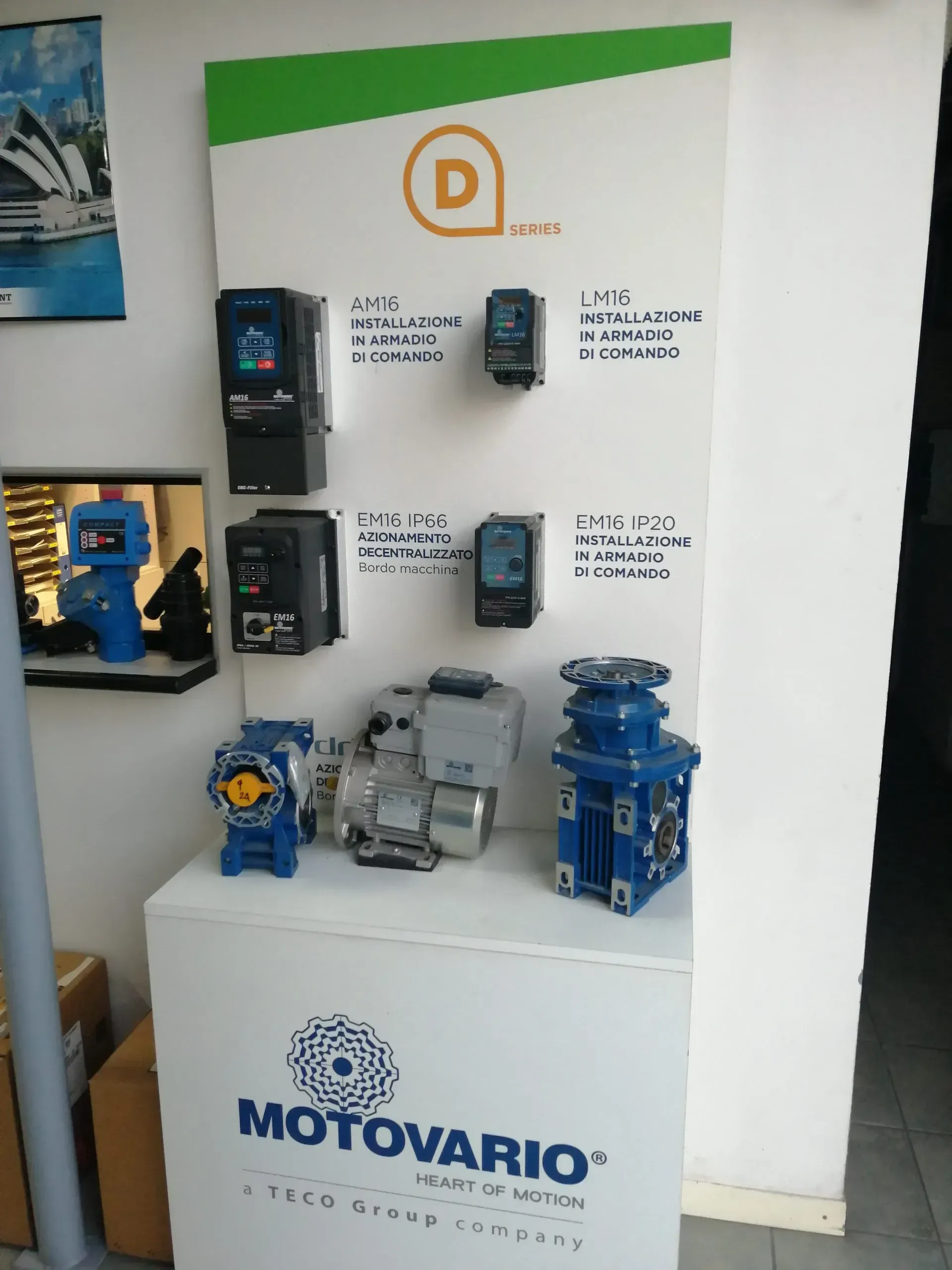 Esposizione di attrezzature industriali Motovario. Insegna bianca con prodotti e logo.