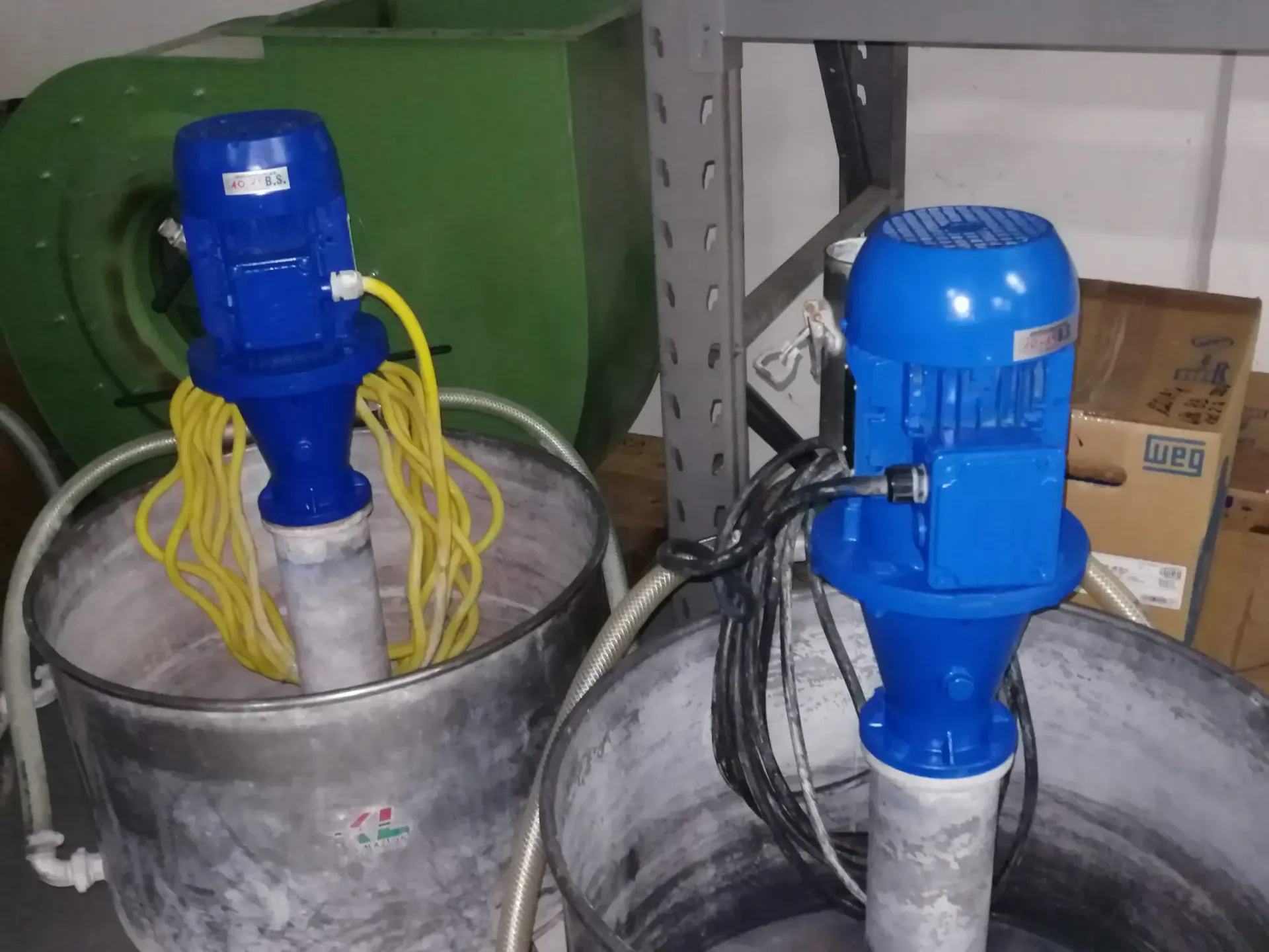 Due frullatori elettrici blu all'interno di contenitori in acciaio inossidabile. Sono visibili i cavi di alimentazione giallo e nero.