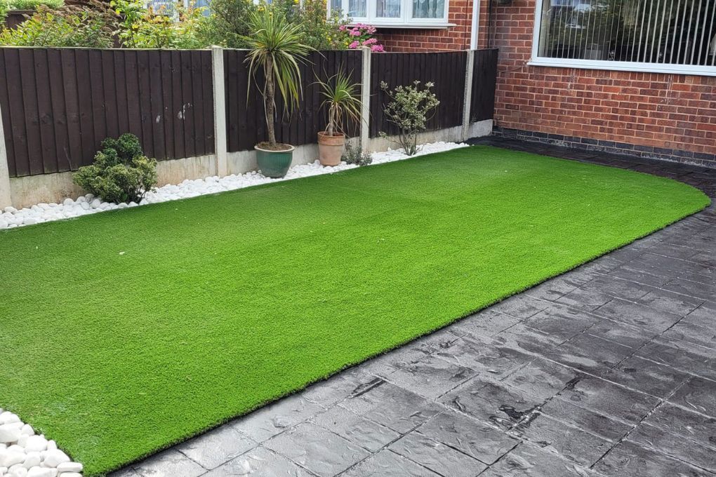 Zest Artificial Grass Bath new fake lawn fitted along a flower bed and imprinted concrete paving