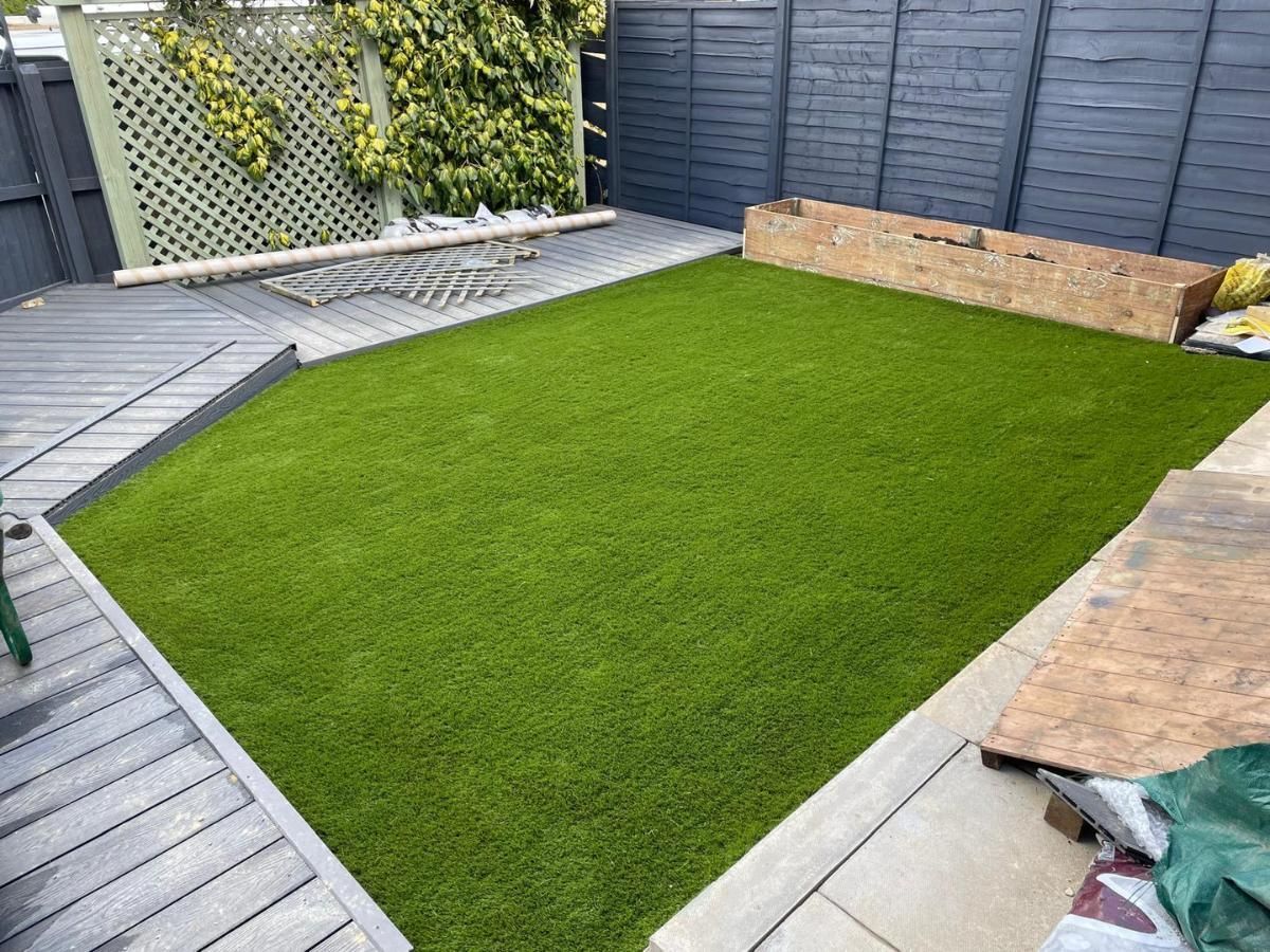 Zest Artificial Grass Dronfield fake lawn fitted along a raised flower bed and decking surround