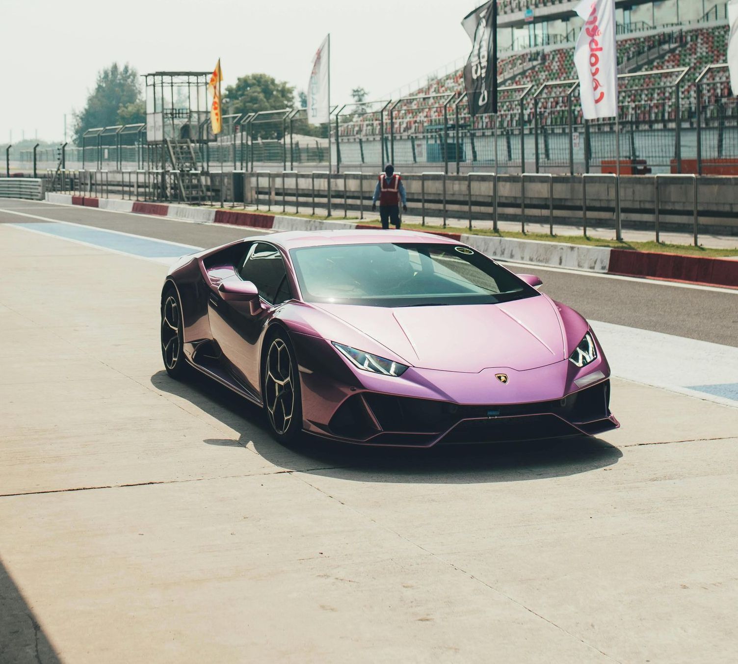 A purple Lamborghini is parked on a race track