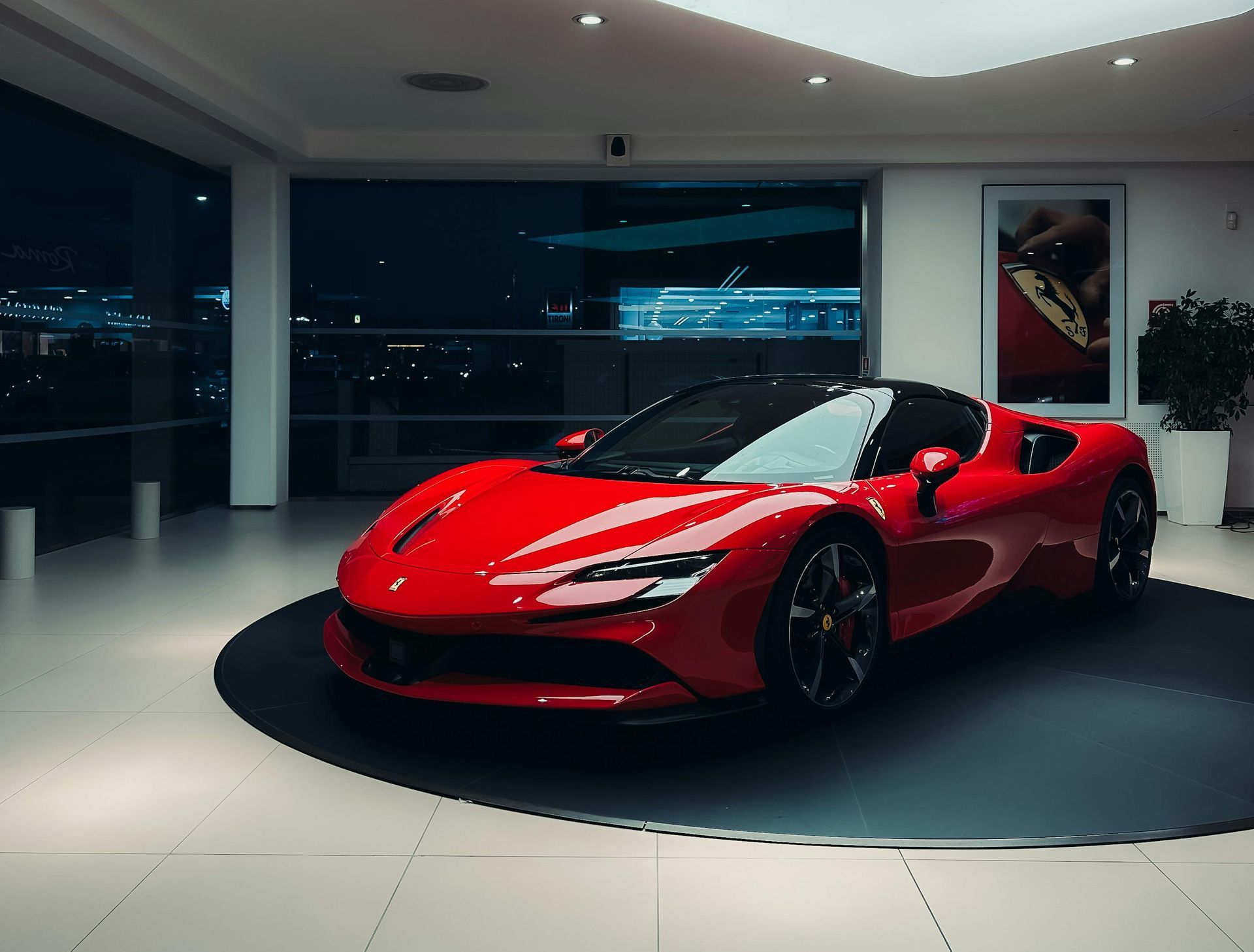 A red sports car is parked in a showroom.