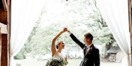 Bride and groom dancing under white curtains outdoors