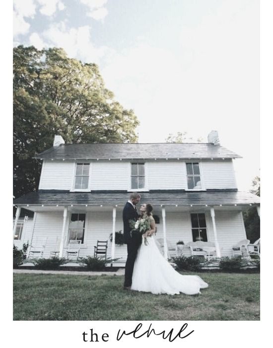 Bride and groom posing in front of a white house with porch, under trees