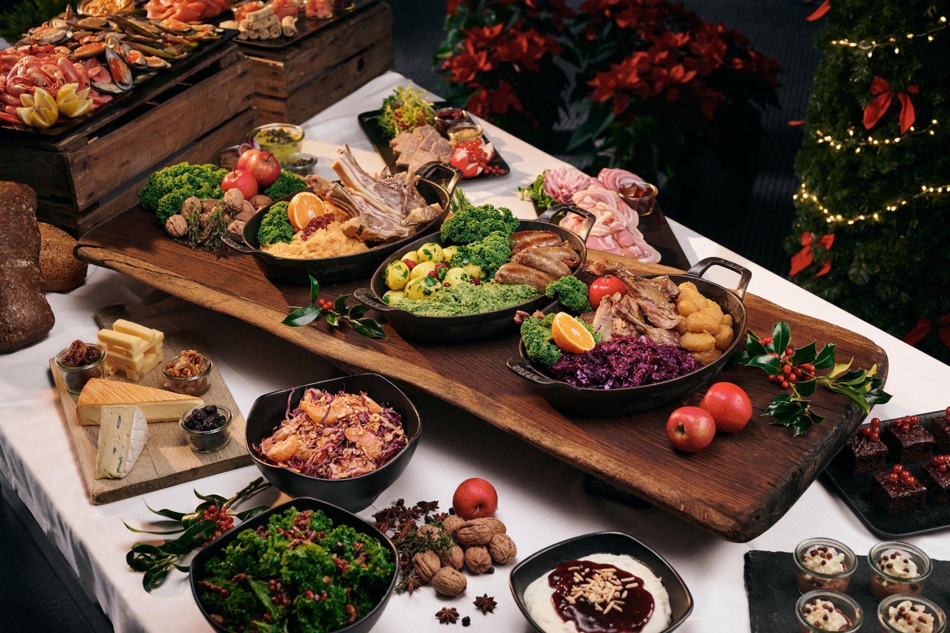 Buffet table with assorted appetizers, salads, bread, and flowers on rustic wooden platters
