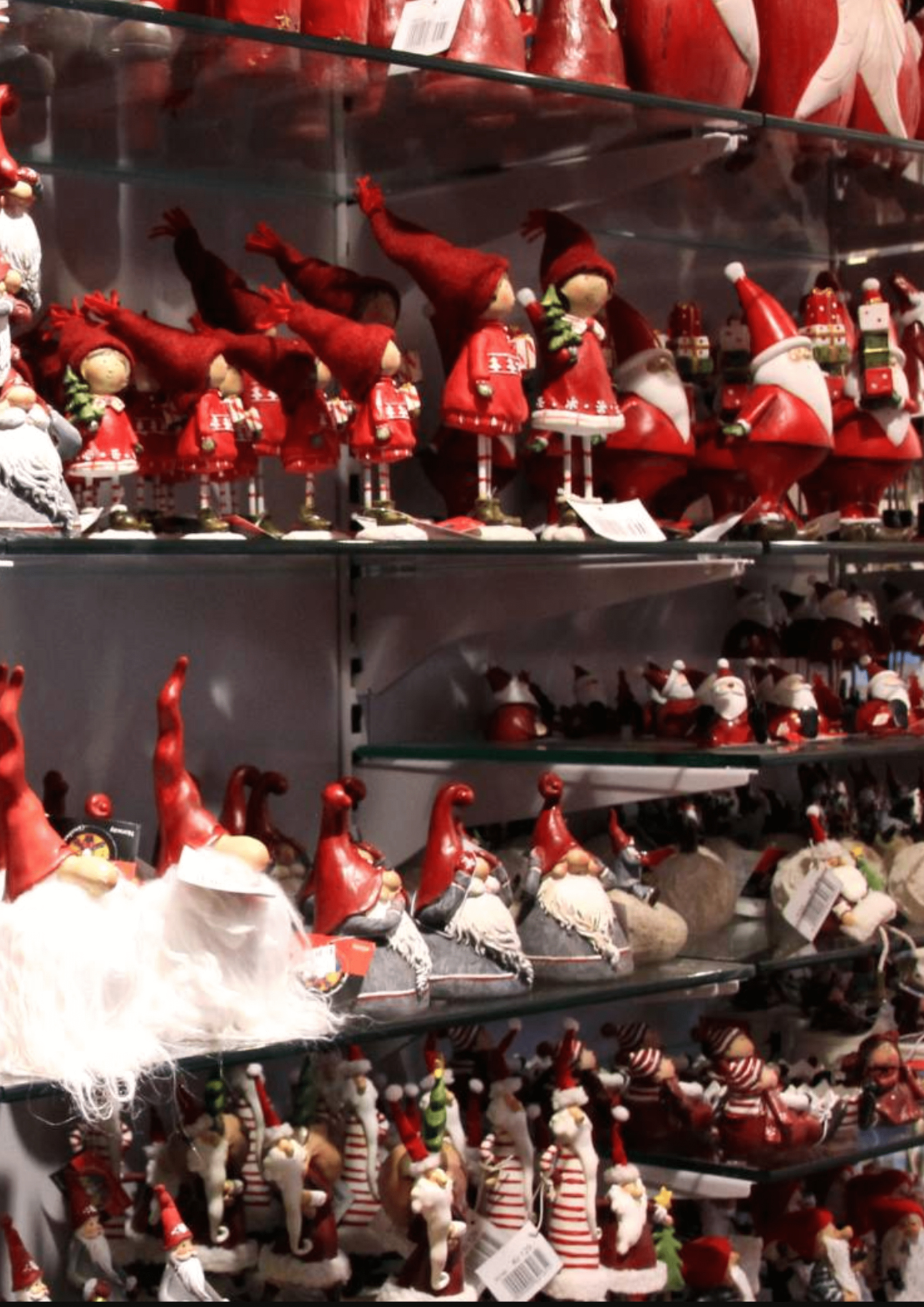 Shelves filled with Christmas decorations, including red gnome figures and Santas.