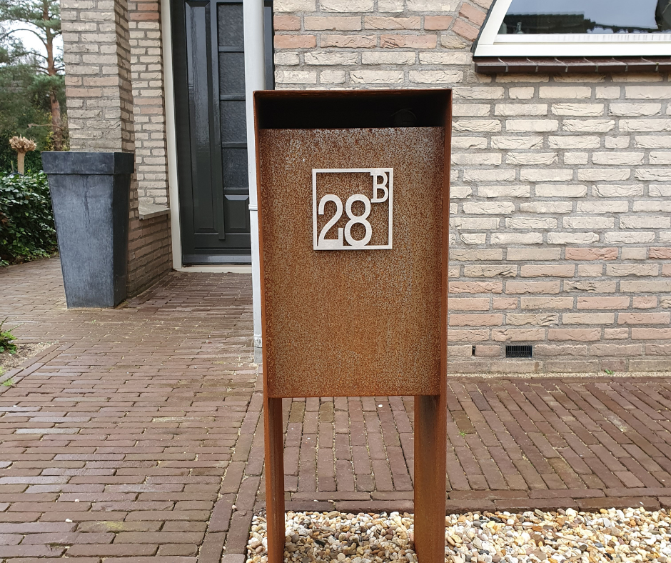 Een roestige brievenbus met het nummer 28 erop