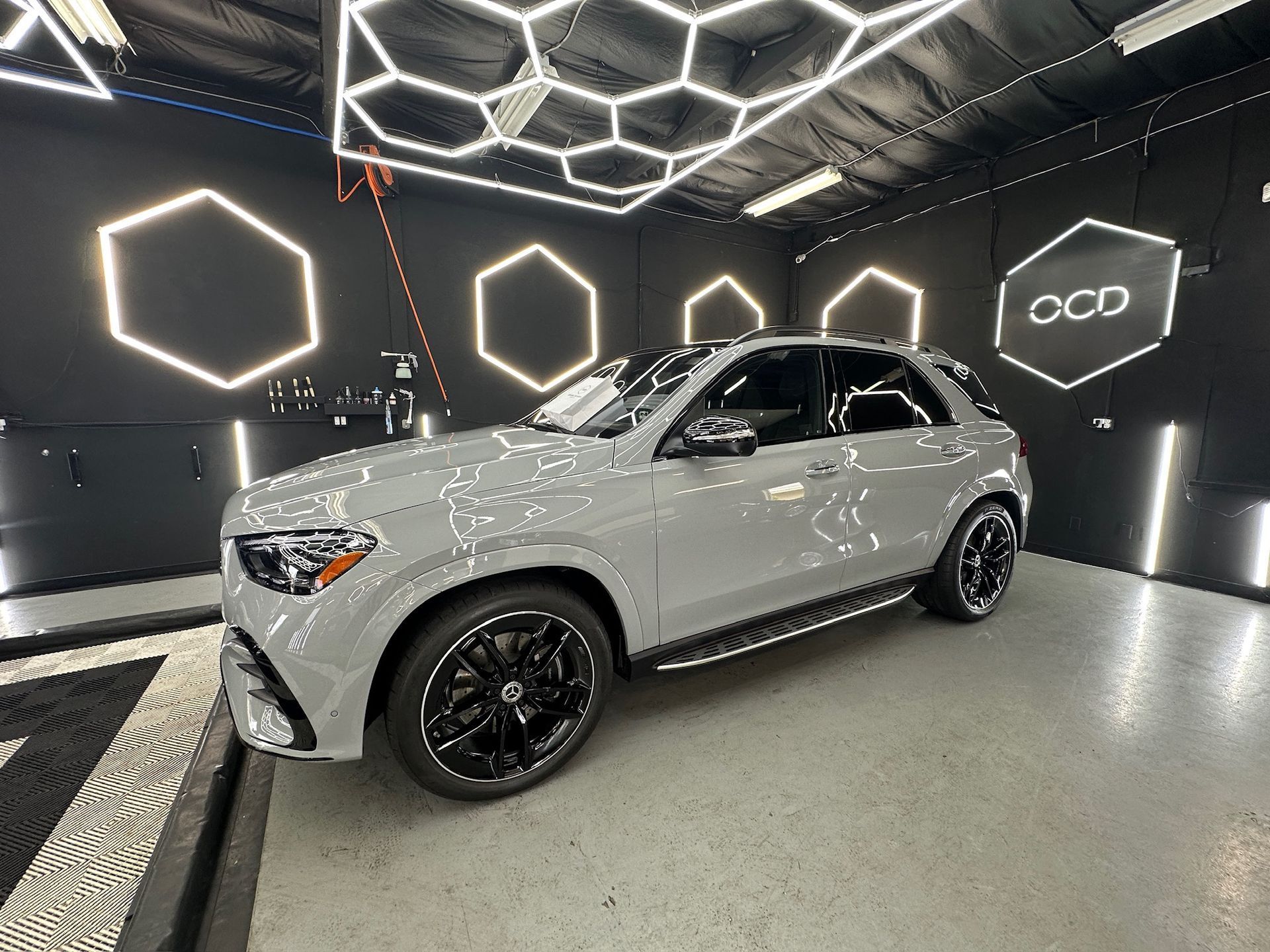 Silver SUV in a modern showroom with hexagonal ceiling lights and black accent walls