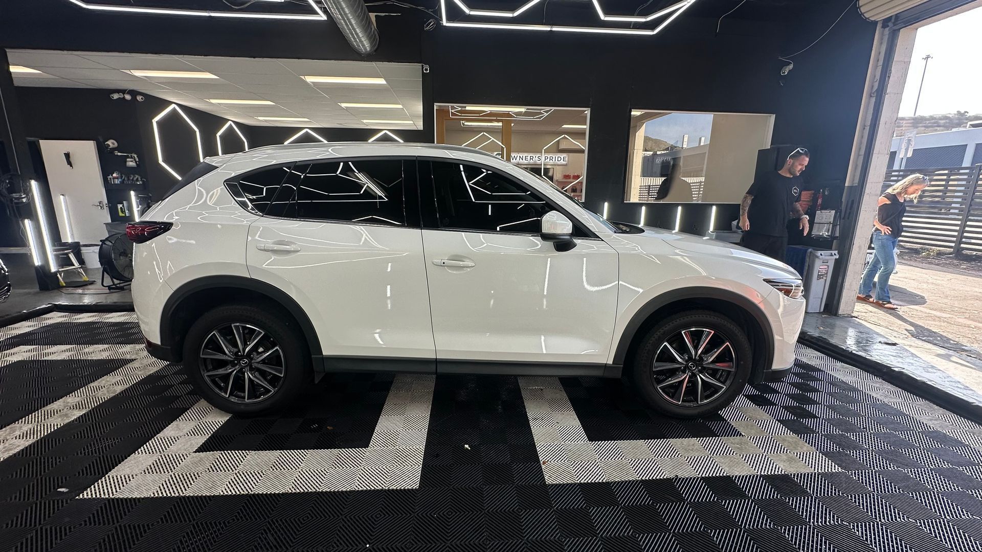 White SUV displayed indoors on a showroom floor under bright lights