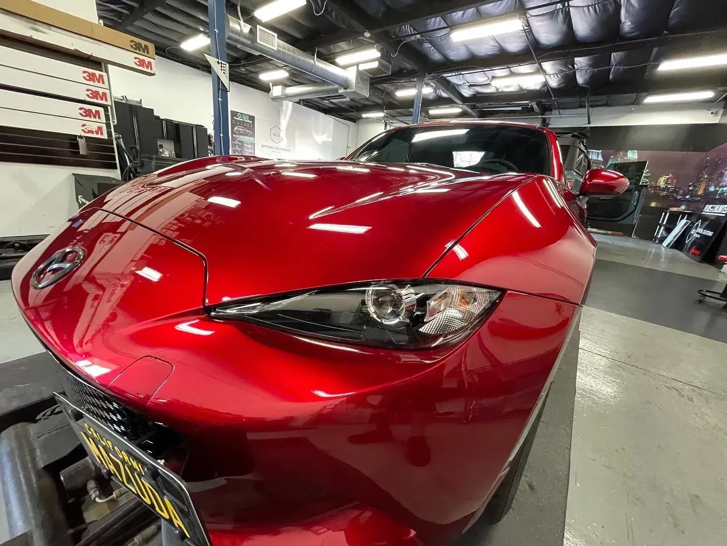Red sports car front end in an auto repair shop
