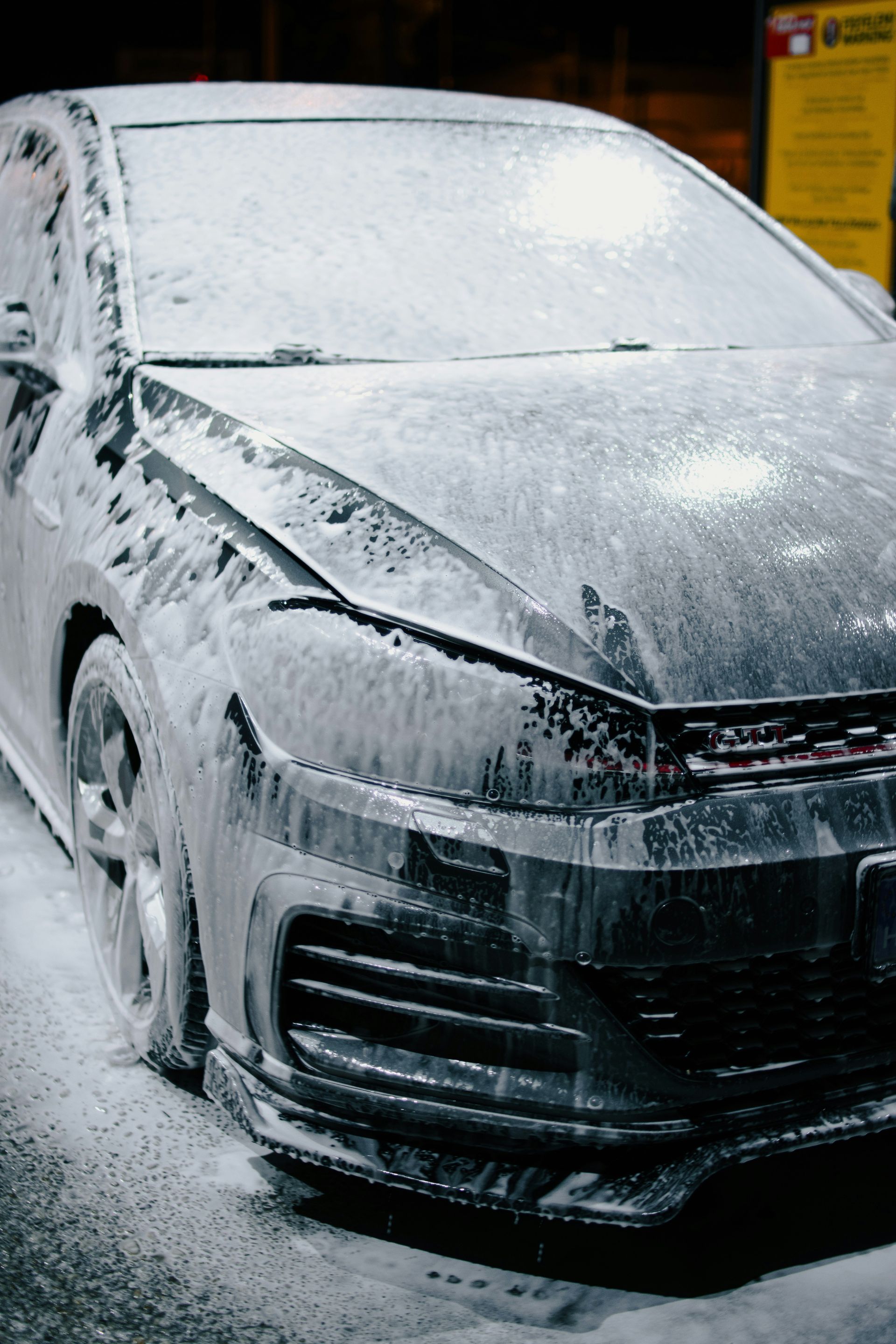 Car covered in thick snow and ice parked outdoors, front view