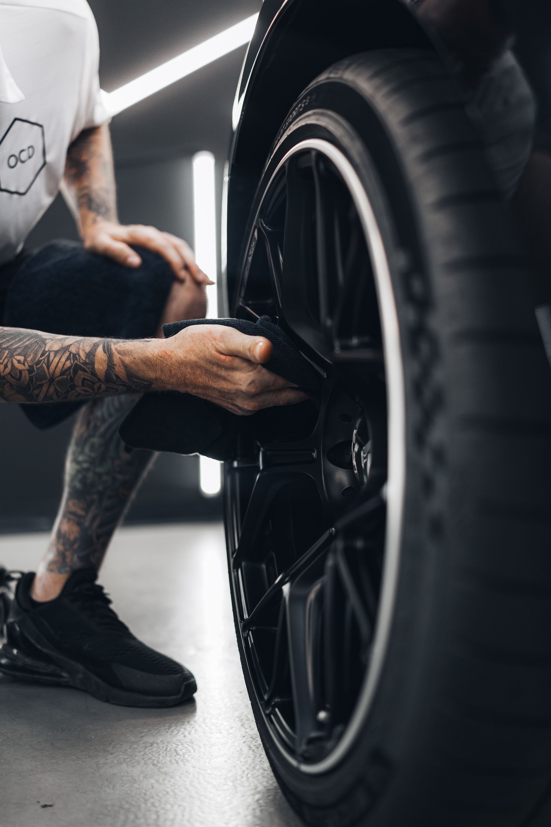 Mechanic tightening lug nuts on a car wheel in a garage