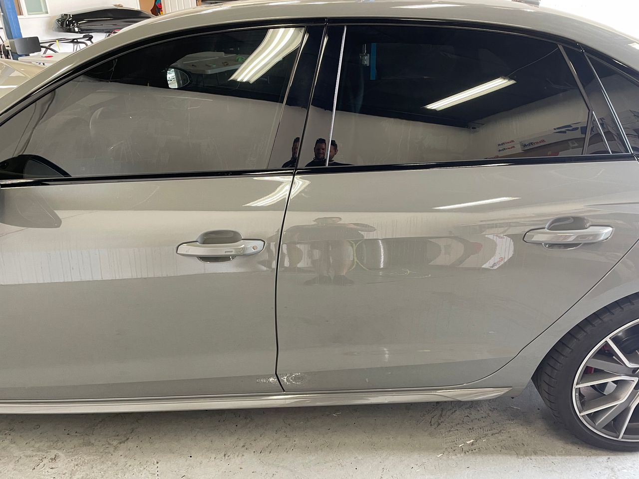 Silver sedan parked indoors, side view with tinted windows and alloy wheels.