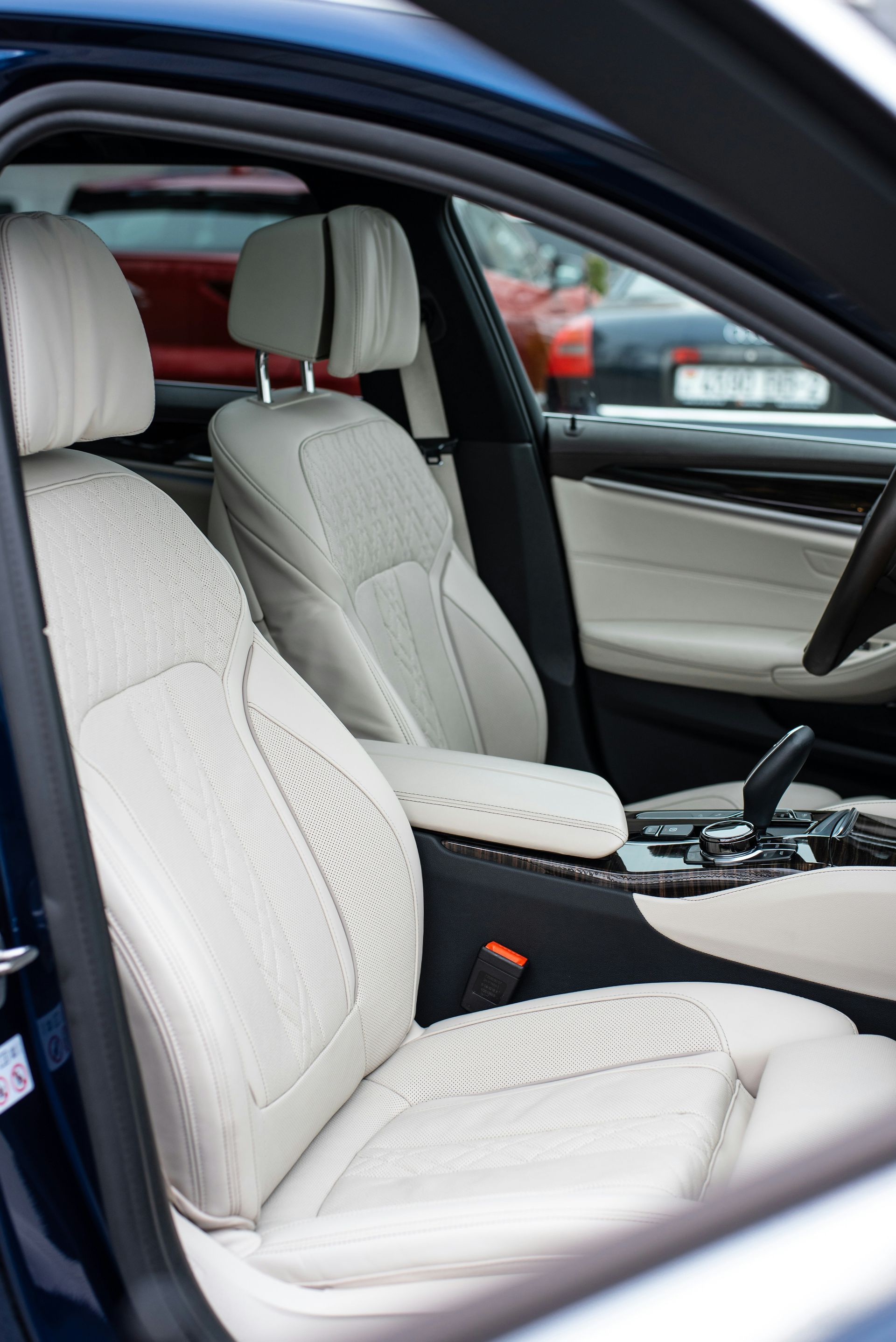 White leather car interior with front seats and center console, viewed through an open door