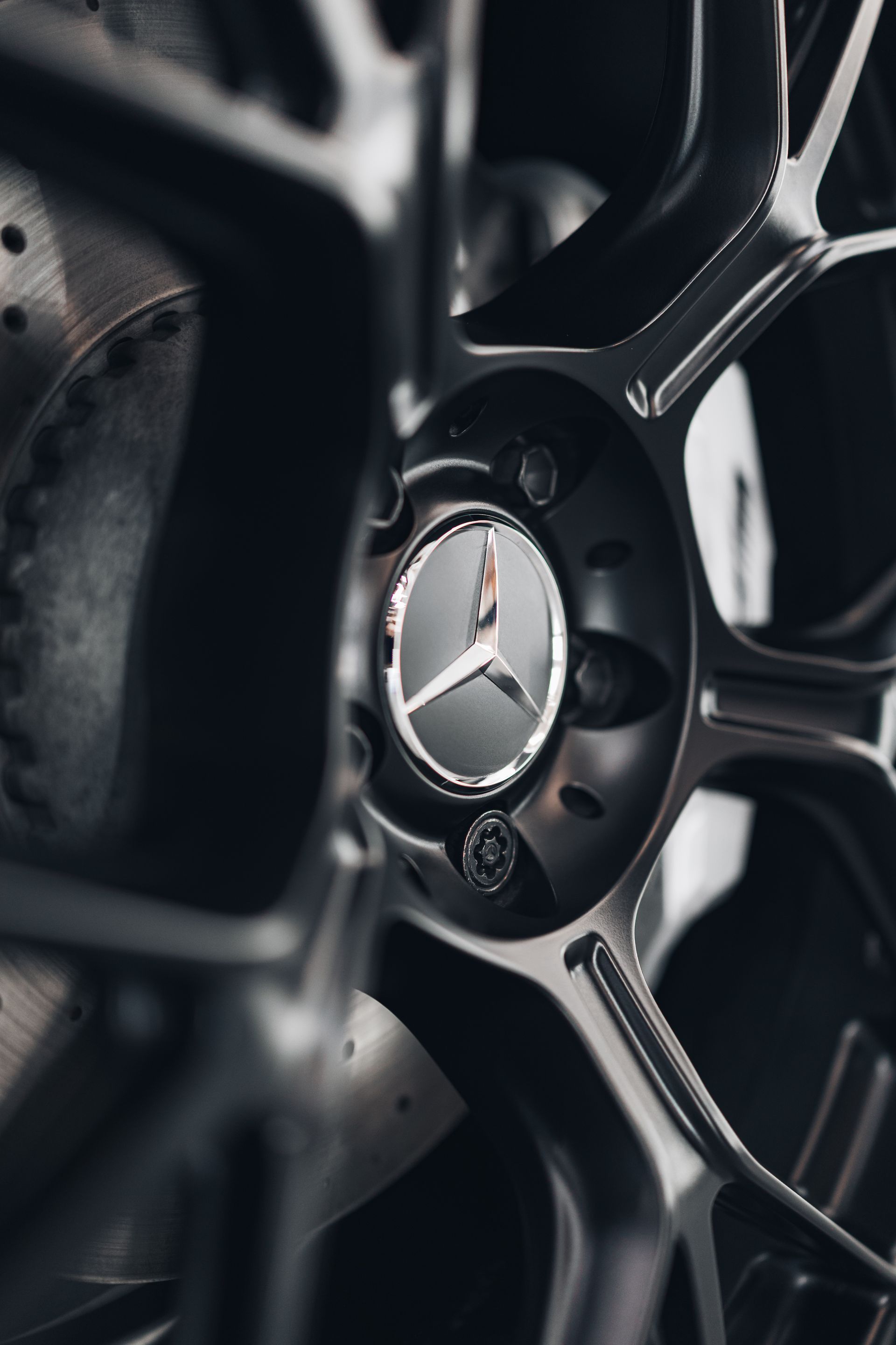 Close-up of a black Mercedes-Benz wheel rim with silver spokes and emblem
