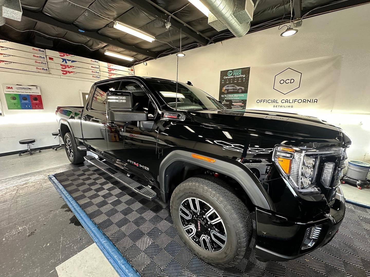 Black pickup truck on a platform inside a showroom or service bay