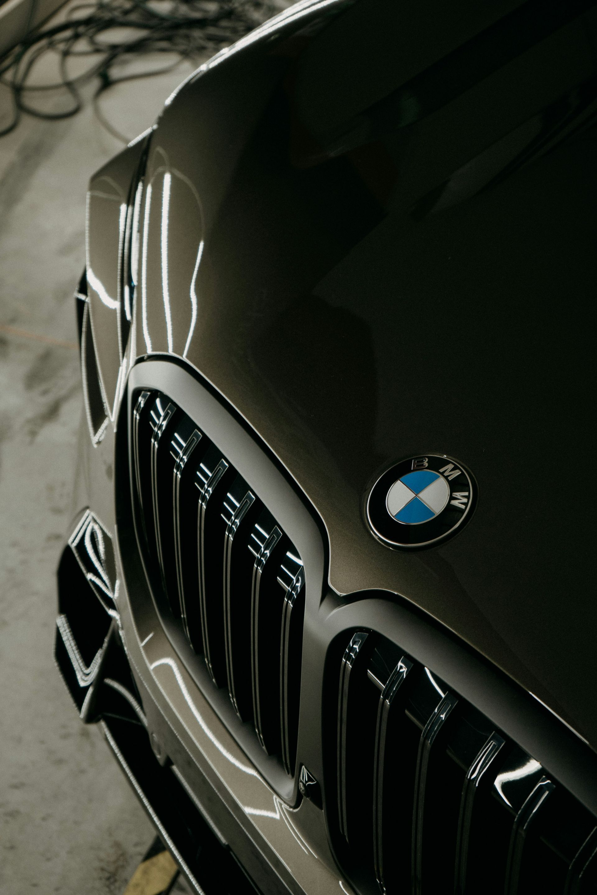 Front view of a black BMW with chrome grille parked indoors