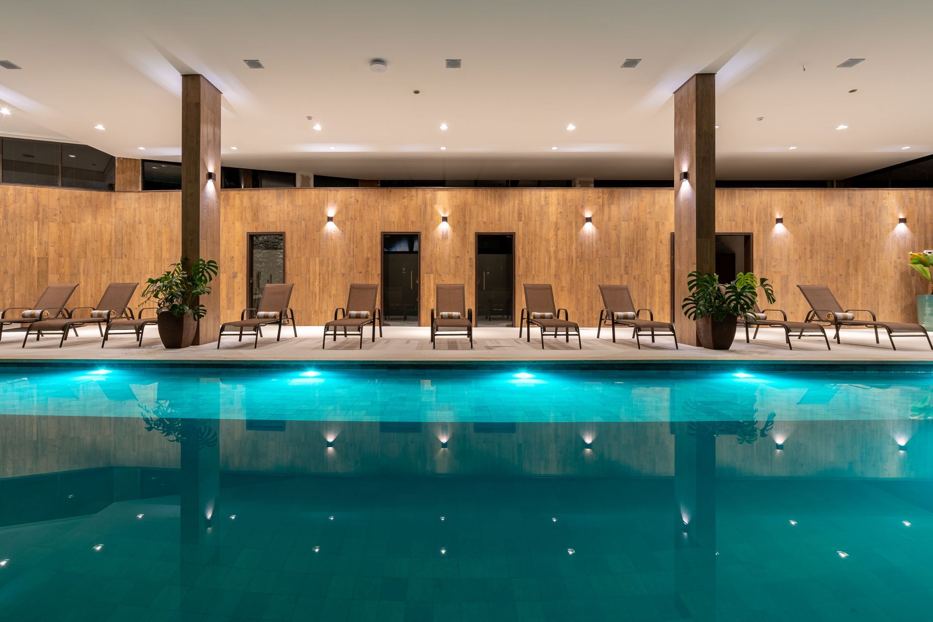 Uma grande piscina coberta com cadeiras ao redor.