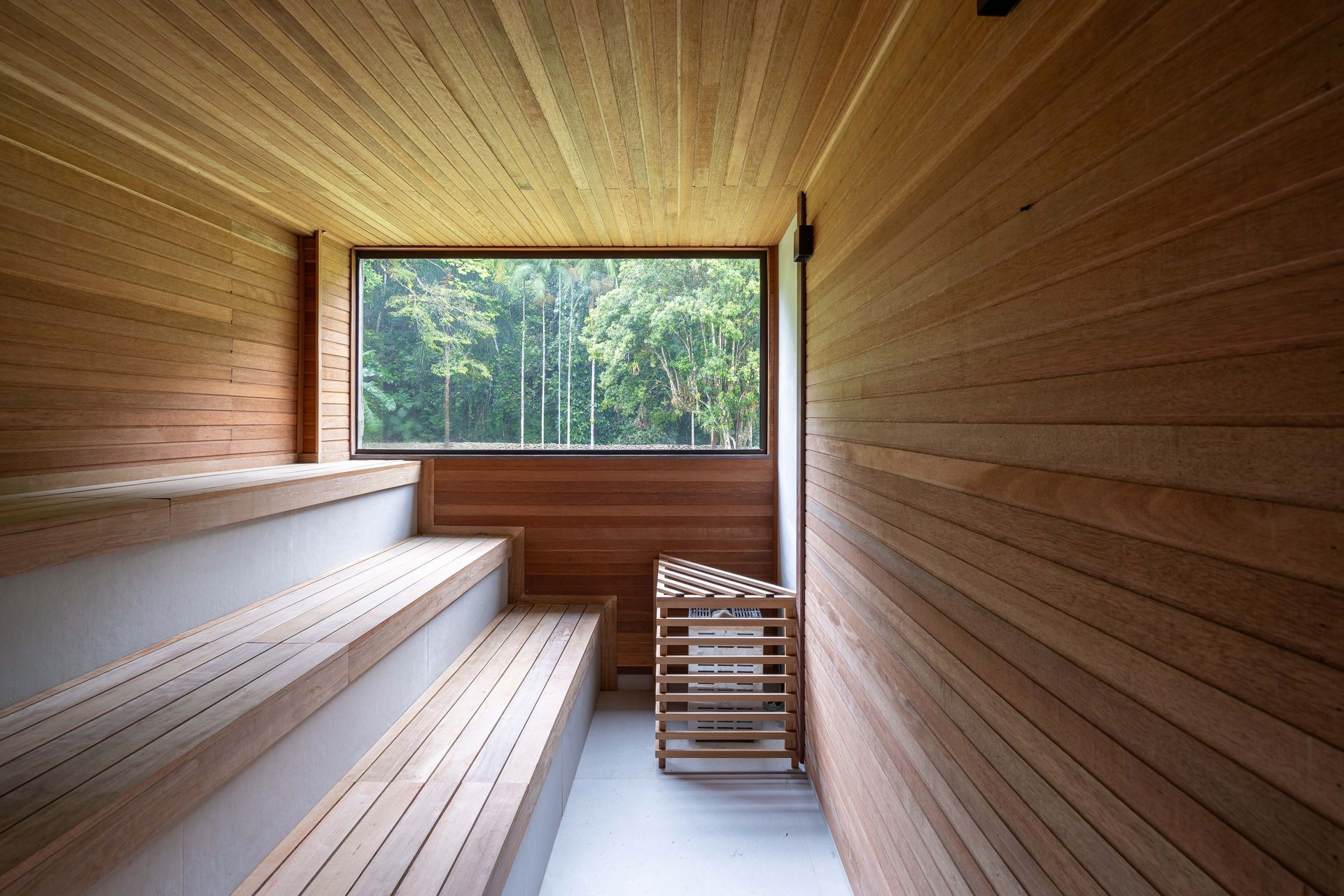 Uma sauna de madeira com uma grande janela e bancos de madeira