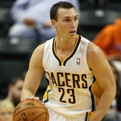 Basketball player holding ball, wearing Pacers jersey.