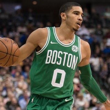Jayson Tatum of the Boston Celtics dribbles a basketball, wearing a green jersey with