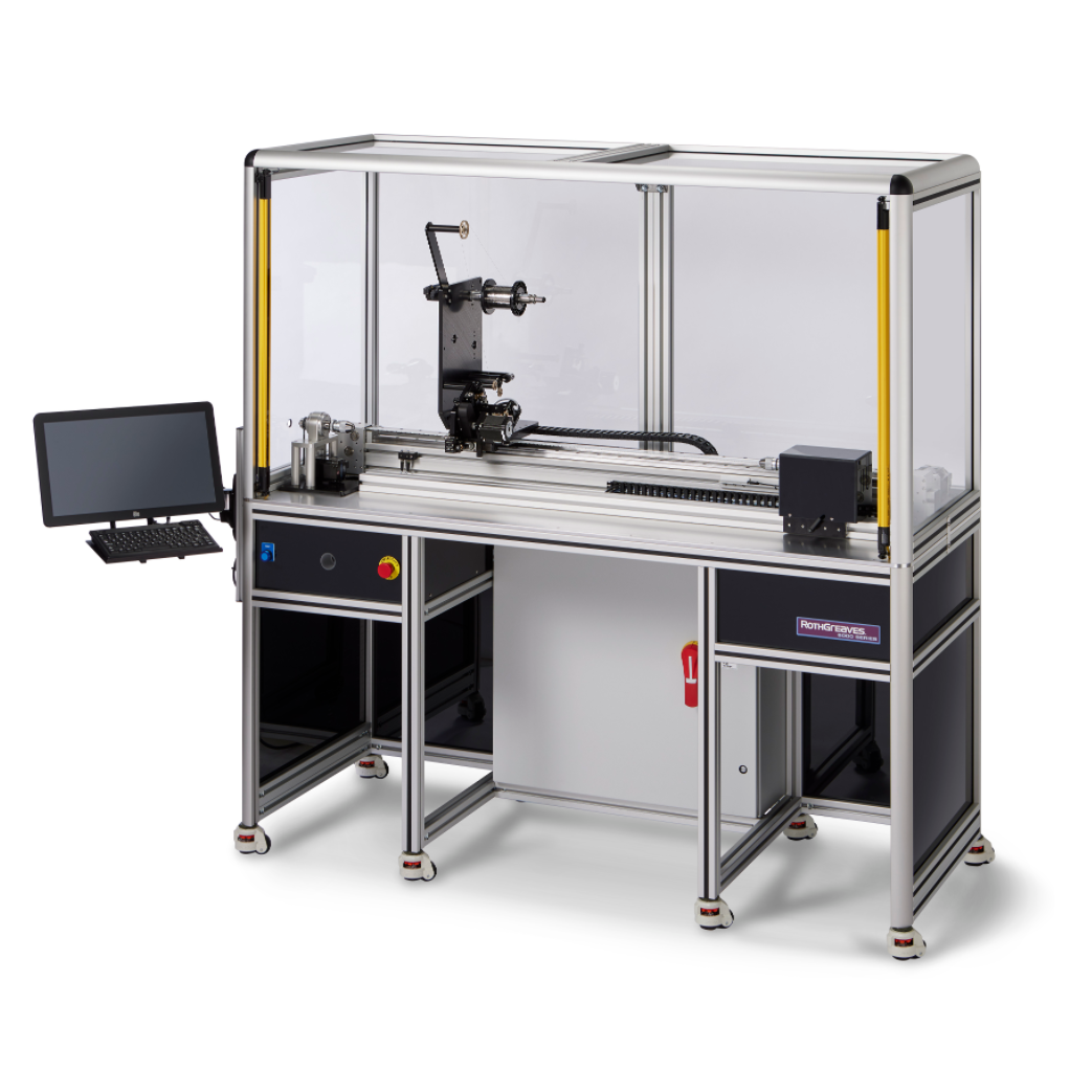 3D printer in an enclosed industrial frame with a monitor on the left and worktable below