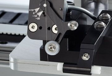 Close-up of a black 3D printer mechanism with a silver base and adjustment dial